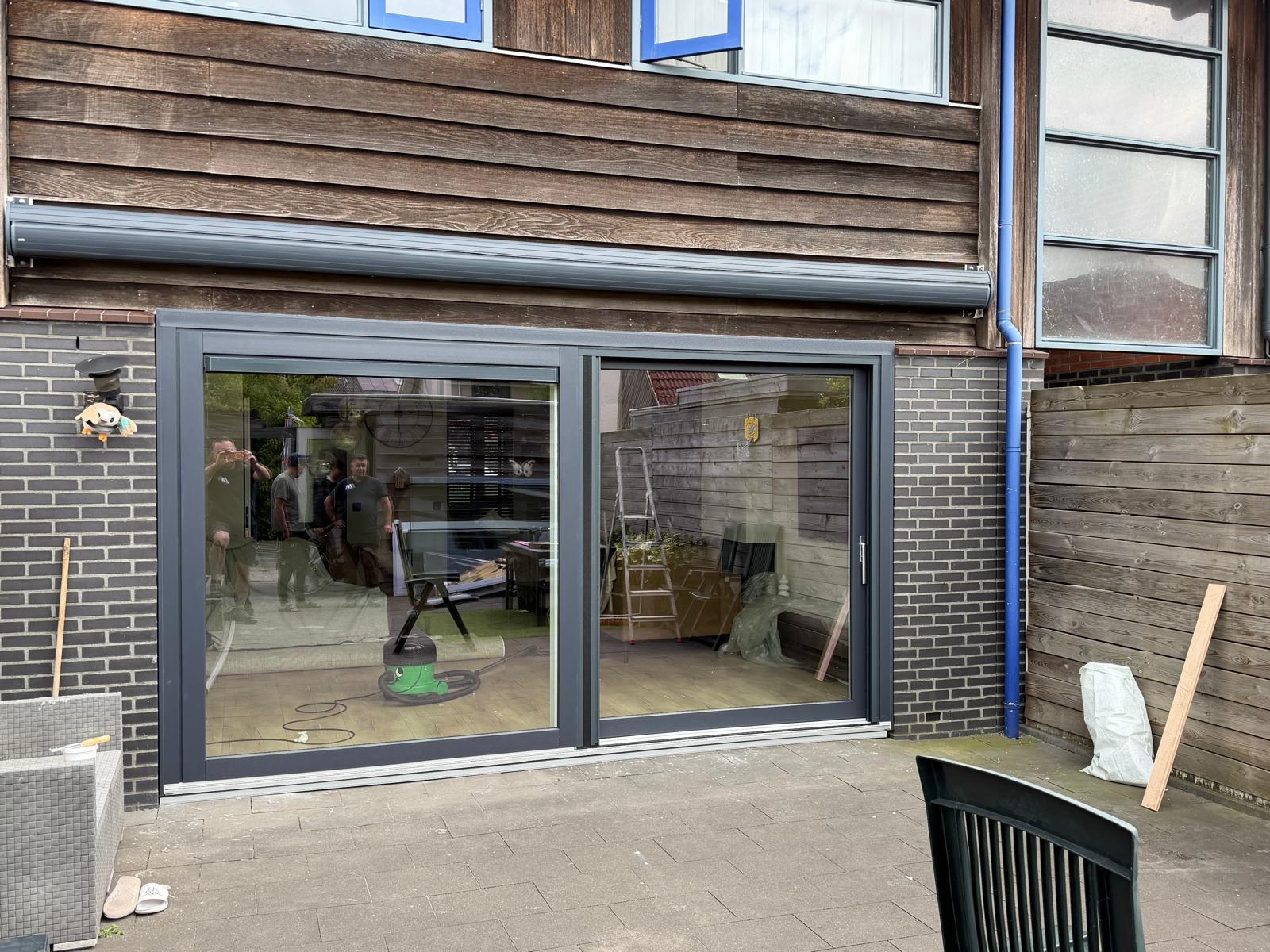 Voorgevel na de renovatie met nieuwe kunststof kozijnen en moderne voordeur